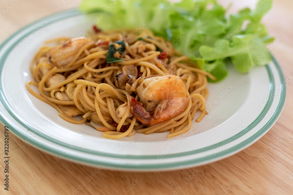 close up Spaghetti shrimp and vegetables on a wooden table close up Spaghetti shrimp and vegetables on a wooden table