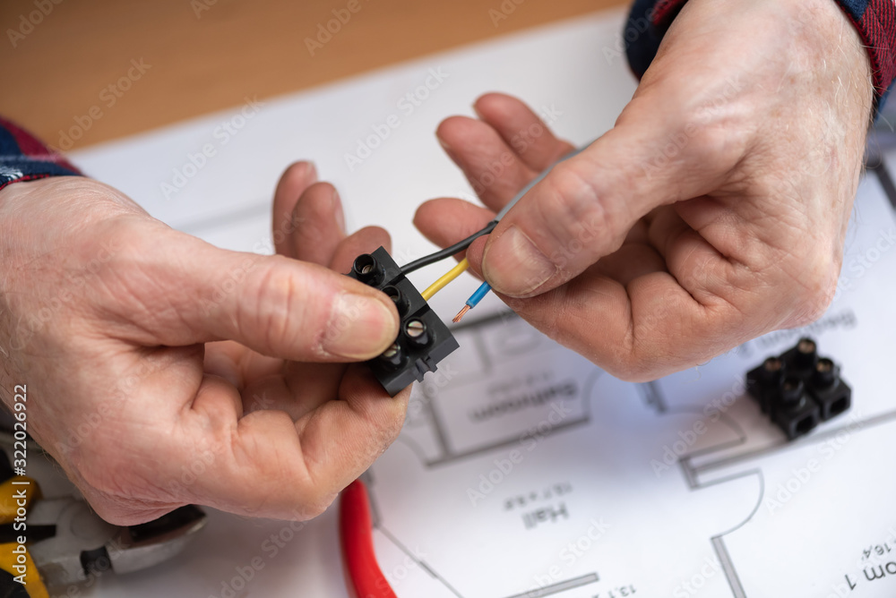 Fototapeta premium Electrician connecting wires in terminal block