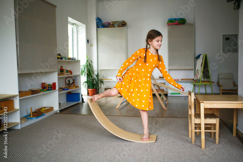 Girl schoolgirl child on balancing wooden board