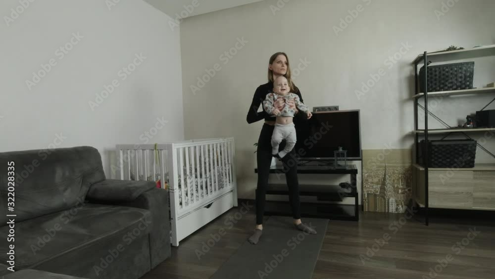Young mother performs an exercise at home with her child. Young mother performs an exercise at home with her child.