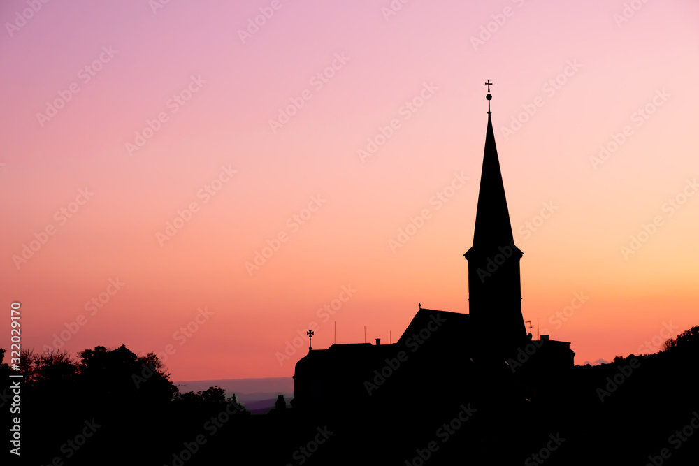 Silhouette view of parish Orthodox church in the evening at Gumpoldskirchen, a famous place for its wine and Heurigers as a great hillside vineyards.