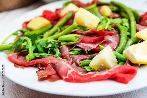 Fresh Sliced raw beef meat with leaf lettuce on the table