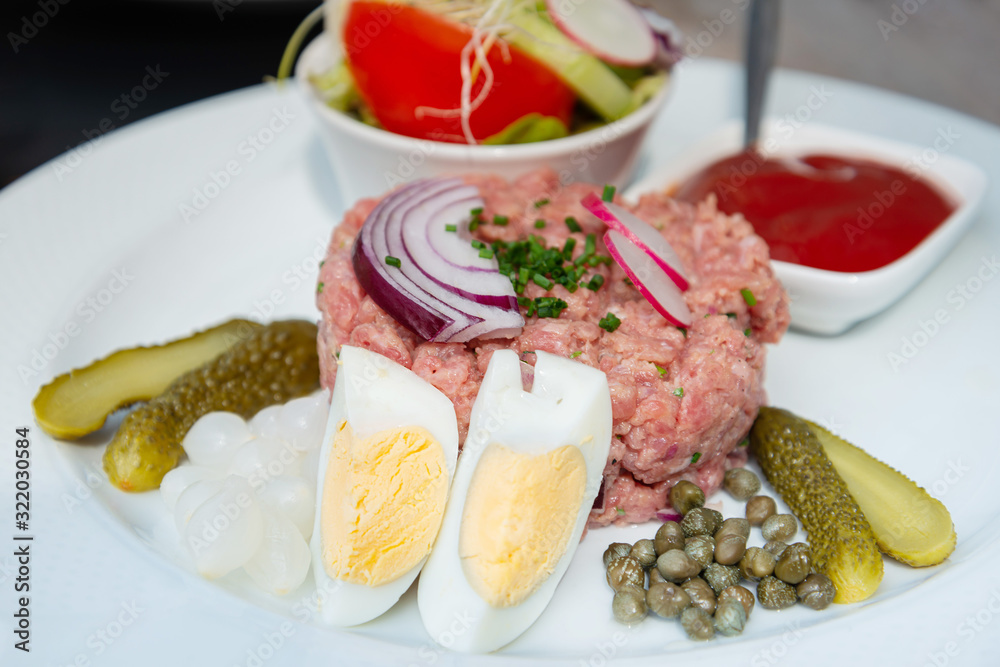 tasty Steak tartare (Raw beef) - classic steak tartare on white plate tasty Steak tartare (Raw beef) - classic steak tartare on white plate