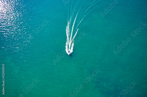 White yacht on blue water in motion. Aerial view