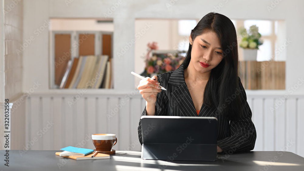 Young beautiful executive woman planning/contemplating about Business growth report while sitting at the modern working table with comfortable working room as background. Young beautiful executive woman planning/contemplating about Business growth report while sitting at the modern working table with comfortable working room as background.