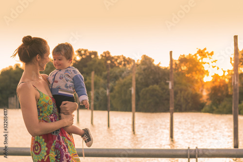 Felicidad de madre e hijo atardecer en el rio photo