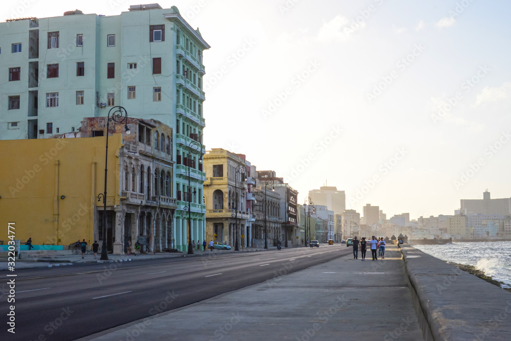 Malecon promenade with cars against the background of old buildings in Havana, Cuba