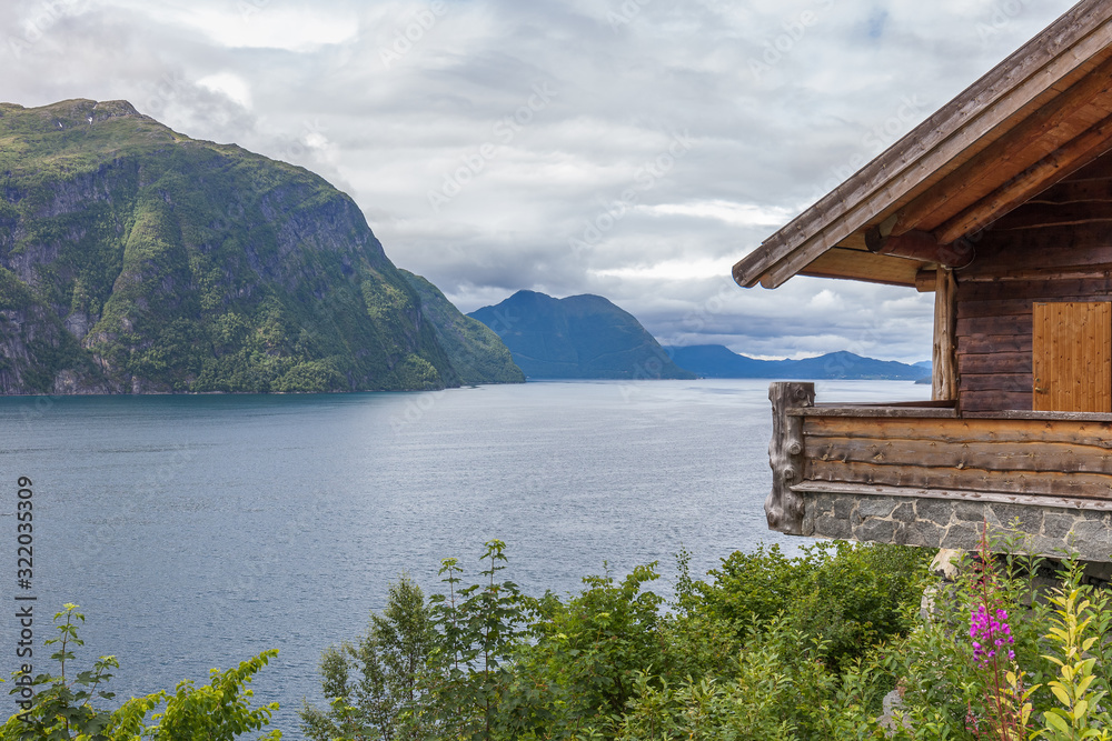 small house in the mountains of the Norwegian fjord with turquoise water