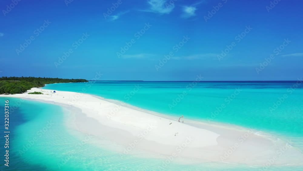 Paradise tropical island with long stripe of white sandy beach surrounded by blue azure sea water under a bright blue sky in Maldives Paradise tropical island with long stripe of white sandy beach surrounded by blue azure sea water under a bright blue sky in Maldives