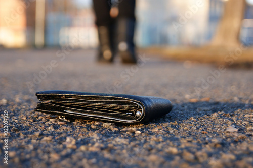 A man lose black wallet on the road. Losing wallet concept.