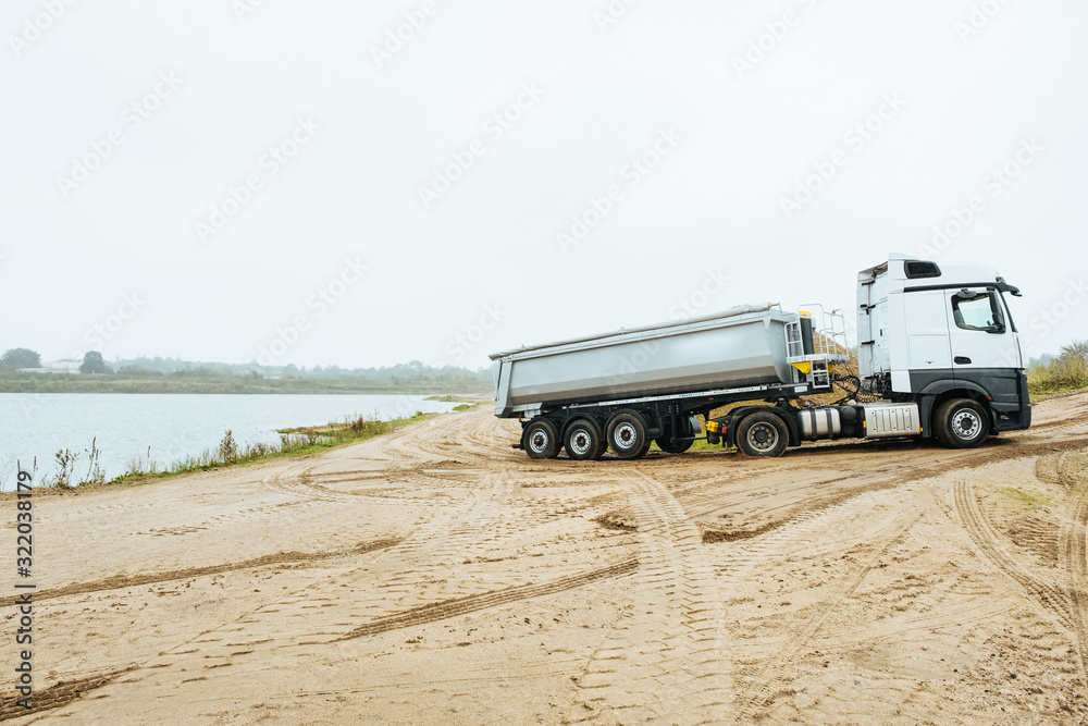 LKW mit Mulden Auflieger transportiert Kies aus einer Kiesgrube LKW mit Mulden Auflieger transportiert Kies aus einer Kiesgrube