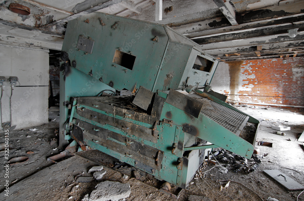 Broken industrial malt equipment at an abandoned brewery