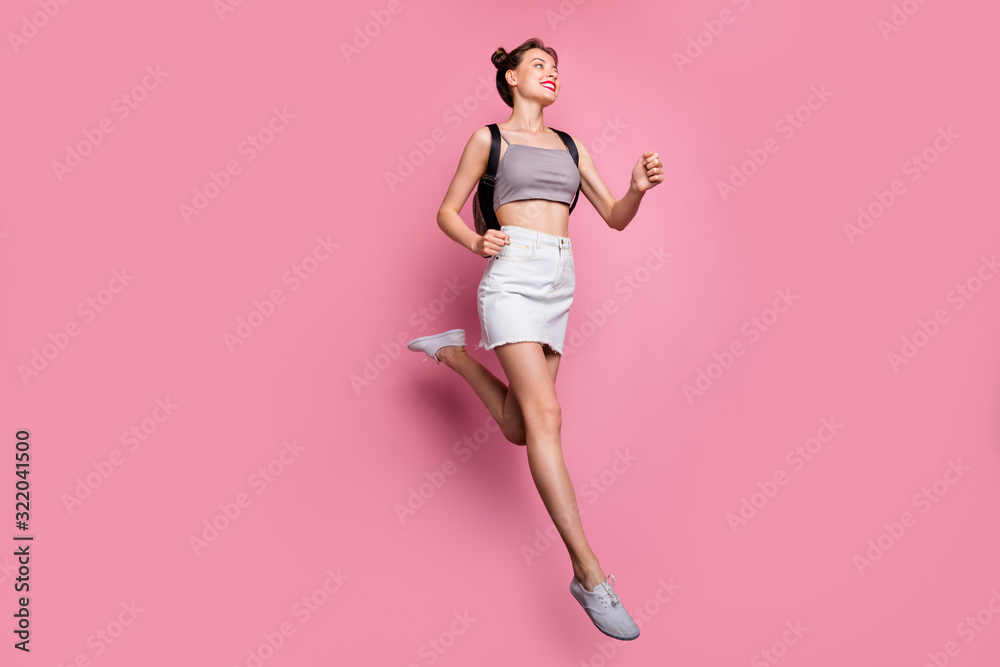 Full length photo of charming cute girl jump run hurry to spring time holidays wear bag casual white trendy clothing isolated over pink color background