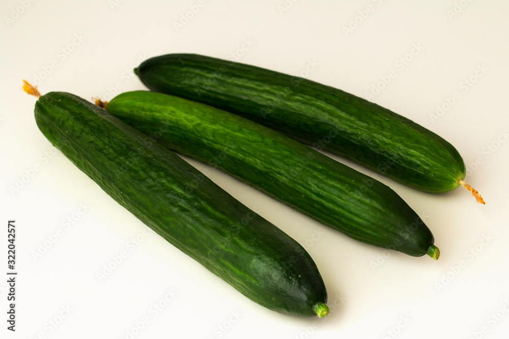 long-fruited smooth cucumbers on a white background long-fruited smooth cucumbers on a white background