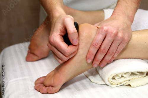 фотографія Woman Receiving Hot Stone Foot Massage