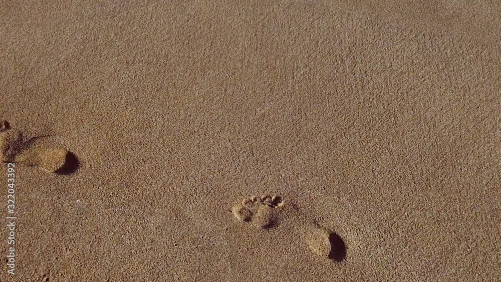 Female footprints in the golden sand. Vacation and travel concept. Moving camera. Female footprints in the golden sand. Vacation and travel concept. Moving camera.