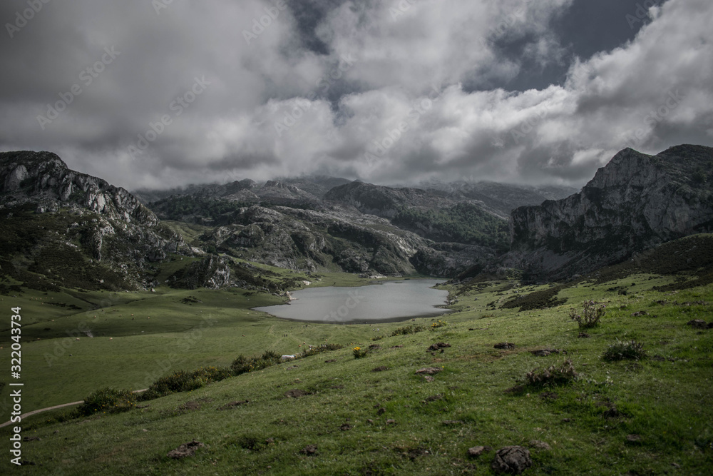 Paisaje nublado rodeado de montañas y lagos