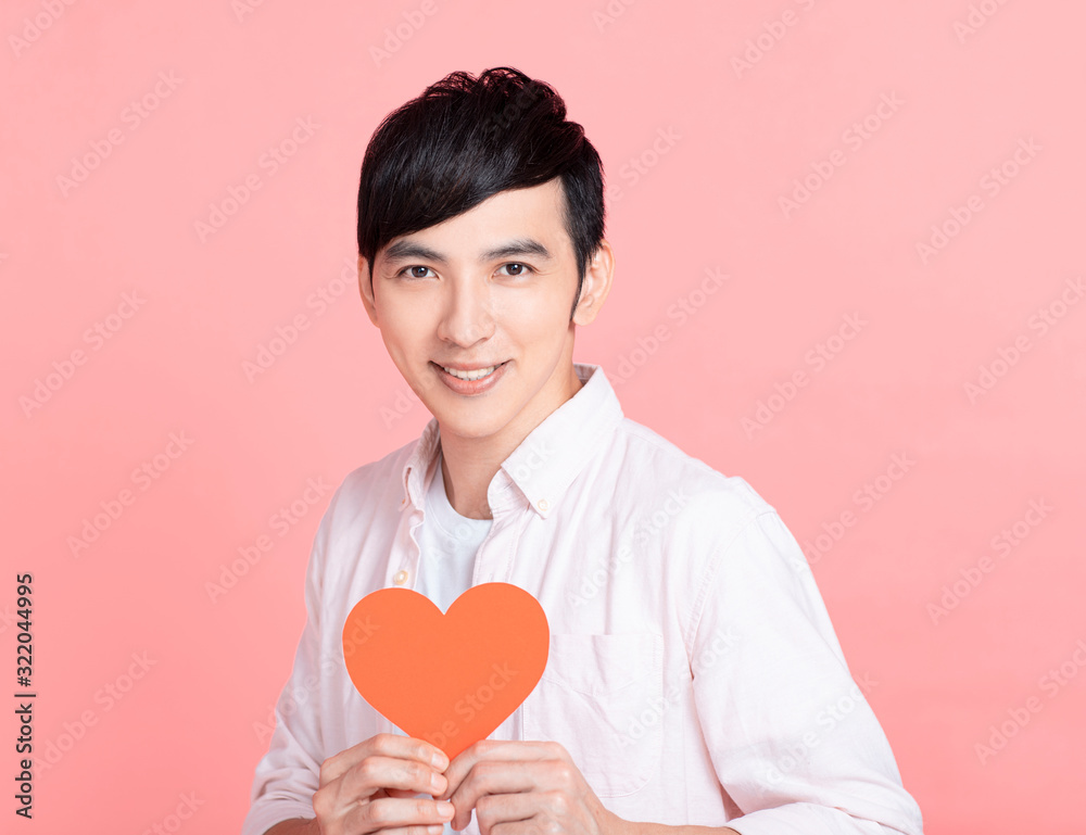 Happy young man holding red paper hearts and celebrating valentines day Happy young man holding red paper hearts and celebrating valentines day