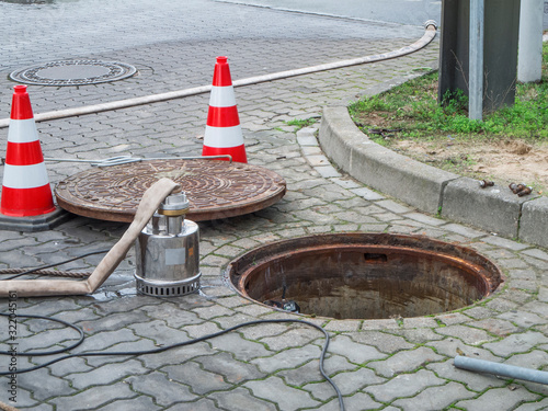 Open sewer with pump and manhole cover