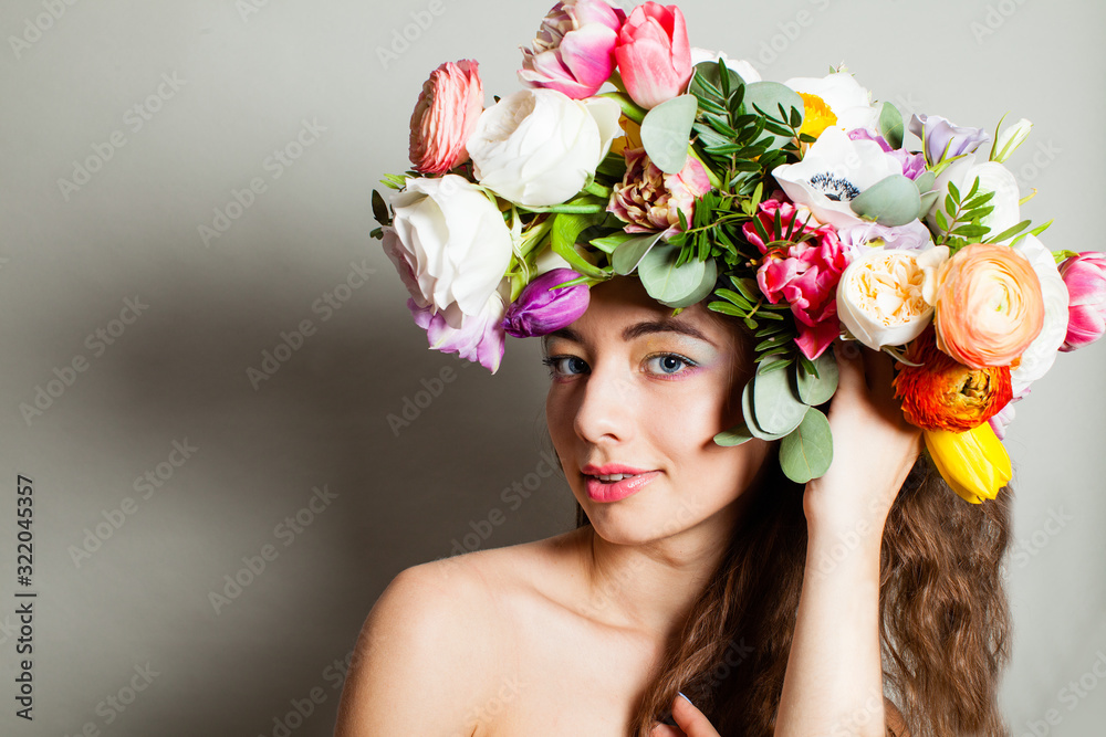 Beautiful woman with long curly hair, perfect makeup and wreath of spring flowers