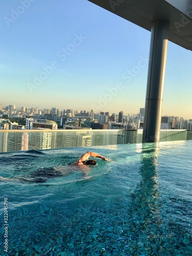 Canvas Print Man swimming in rooftop pool on skyscraper, Singapore, South East Asia