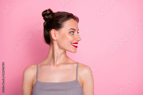 Closeup profile photo of pretty amazing young lady funny buns red pomade looking empty space wear casual summer grey tank-top isolated pastel pink color background