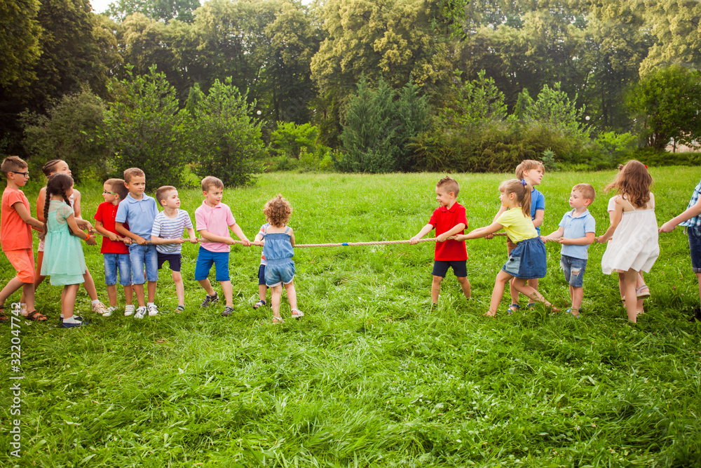 Obraz premium Group of kids are playing tug of war
