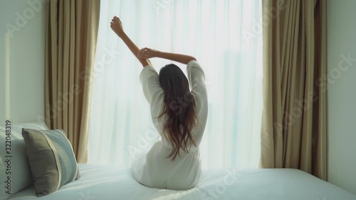 Wallpaper Mural Elegant brunette in white bathrobe sits on French bed and stretches, behind Torontodigital.ca