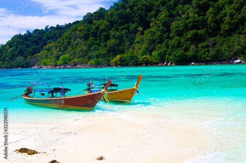 View on secluded beach in remote bay with turquoise water and thai long-tail boats, Ko Lipe, Thailand