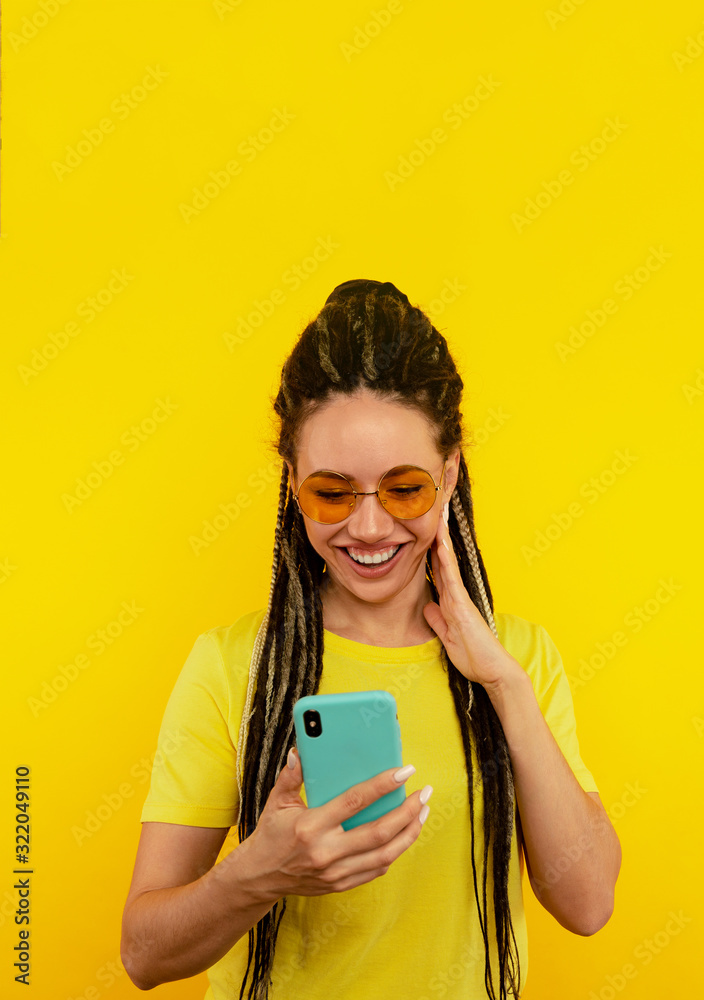 Happy smiling woman with bright phone in the yellow studio Happy smiling woman with bright phone in the yellow studio