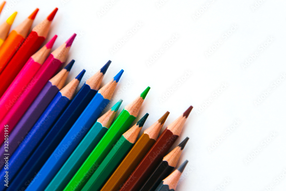 bright multi-colored flat lay pencils for drawing on a white background, place for text 