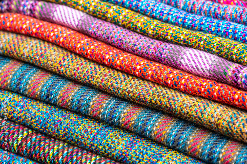 A pile of colorful traditional Andes textiles on the local indigenous market of Otavalo, Ecuador. This type of fabrics is also found in Bolivia and Peru.