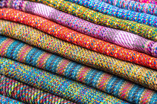 A pile of colorful traditional Andes textiles on the local indigenous market of Otavalo, Ecuador. This type of fabrics is also found in Bolivia and Peru.