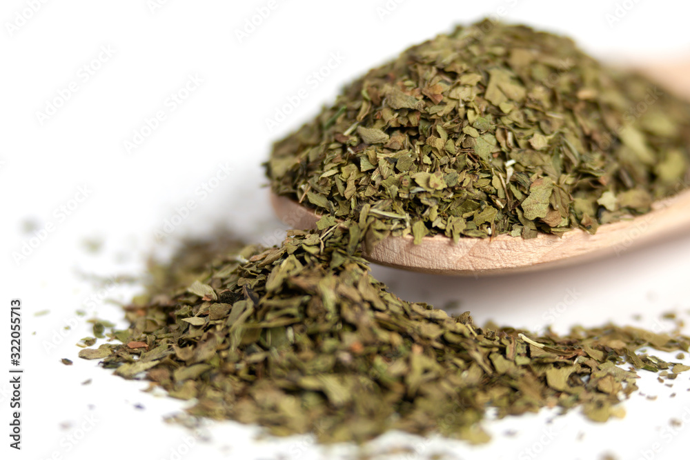 dried lovage herb in wooden spoon isolated on white background. spices and food ingredients. spices and food ingredients dried lovage herb in wooden spoon isolated on white background. spices and food ingredients. spices and food ingredients