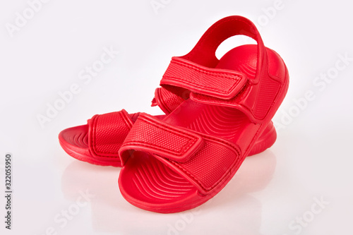 Children's red rubber sandals with Velcro isolated on the white background. Kids beach summer shoes