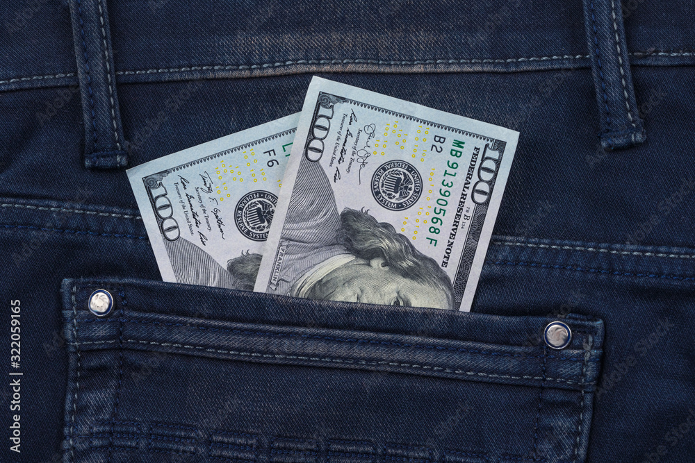 One hundred dollar banknote money in pocket jeans pants background texture. 100 dollar bill close up One hundred dollar banknote money in pocket jeans pants background texture. 100 dollar bill close up