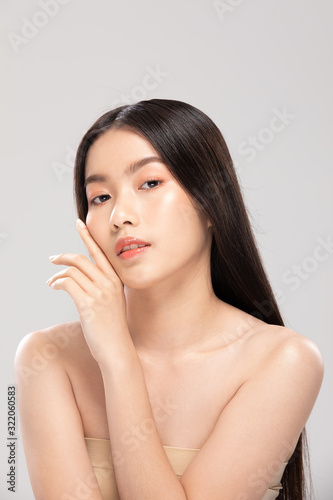 Beautiful Asian young woman touching soft cheek smile with clean and fresh skin Happiness and cheerful with positive emotional isolated on white background Beauty and Cosmetics Concept