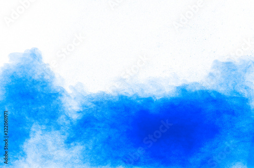 Blue color powder explosion cloud on white background.Closeup of Blue dust particles splash on background. © Pattadis
