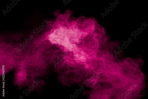 Pink powder explosion on black background.Pink dust splash cloud on dark background.