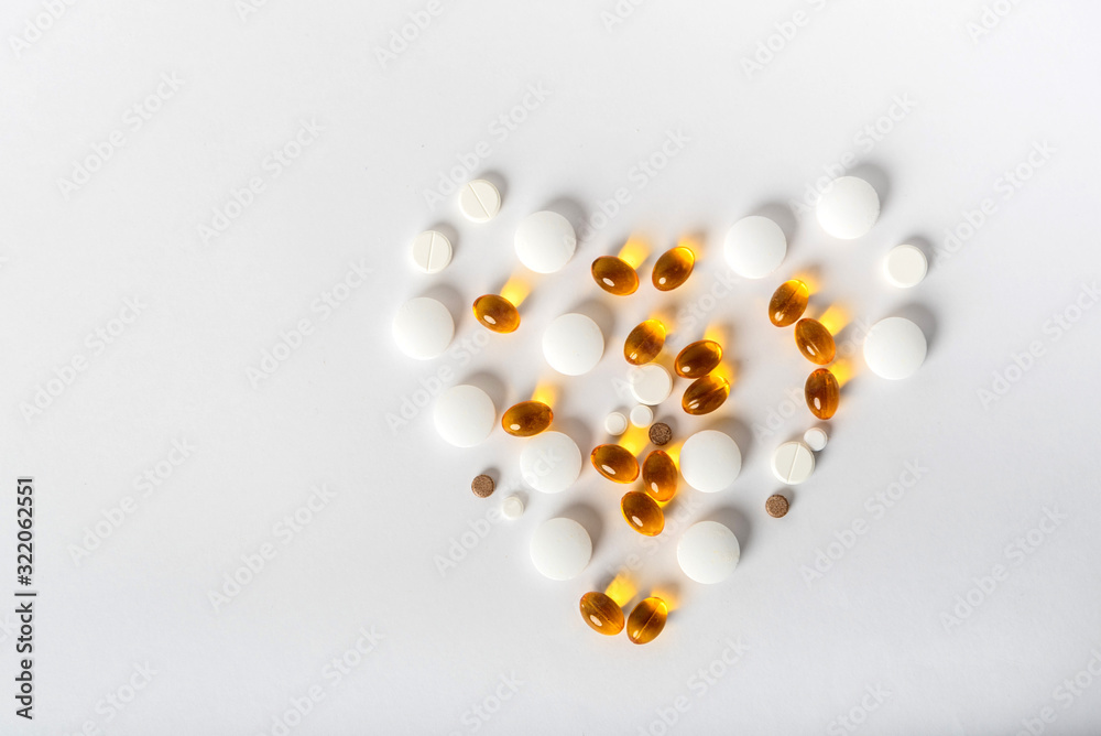 scattered pills of different shapes and colors on a white background