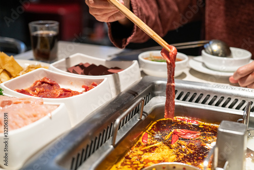 Chinese Hotpot shabu spicy and sour soup with meat and seafood, Suki Chinese style - selective focus