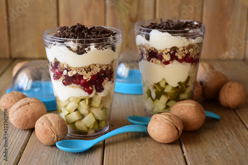 Vegetarian Breakfast in the Bank. Muesli, cranberries, chocolate, pears in a transparent jar on a wooden table.