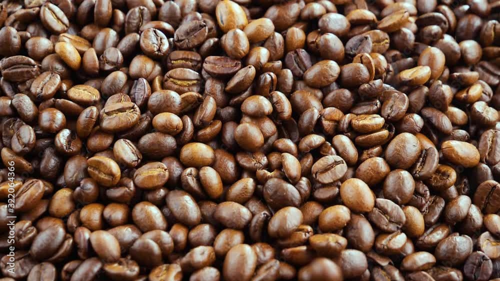 The coffee beans are roasted and mixed with a spoon. 