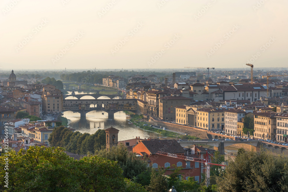 Panoramic view of famous Ponte Vecchio bridge with river Arno at sunset in Florence, Italy.