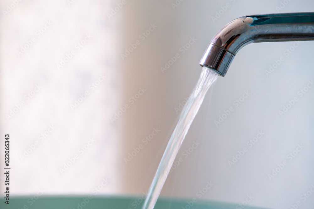 Water flowing from faucet to green washbasin, Bathroom concept Water flowing from faucet to green washbasin, Bathroom concept