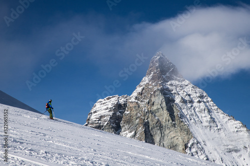 skiing under Matterhorn peak against blue sky Swiss Alps