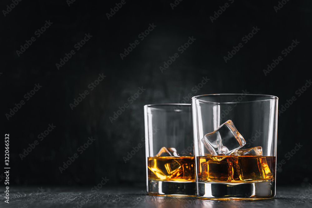 two glasses of alcoholic drink on a dark background