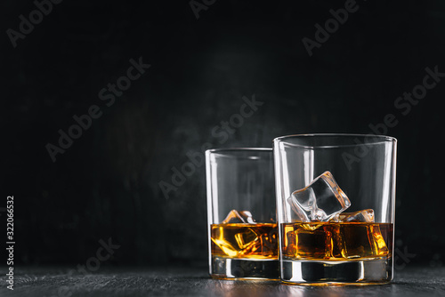 Billede på lærred two glasses of alcoholic drink on a dark background