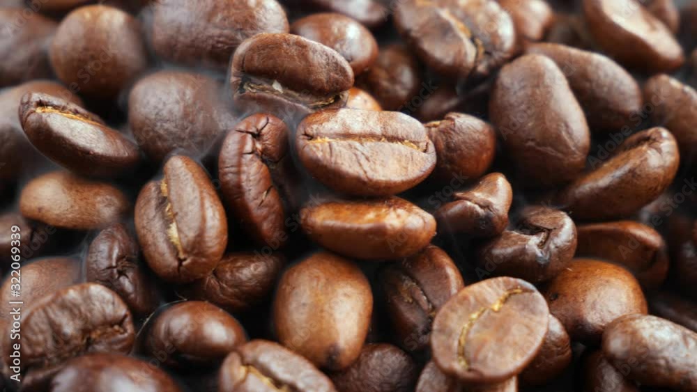 Coffee beans are fried in a pan and mixed with a spoon Coffee beans are fried in a pan and mixed with a spoon