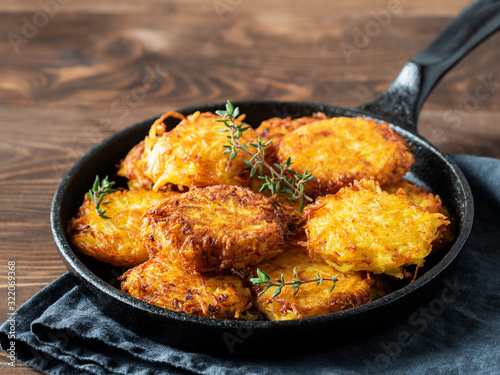 Potatoes pancakes latkes, flapjacks, hash brown or potato vada on brown wooden table. Copy space for text. photo